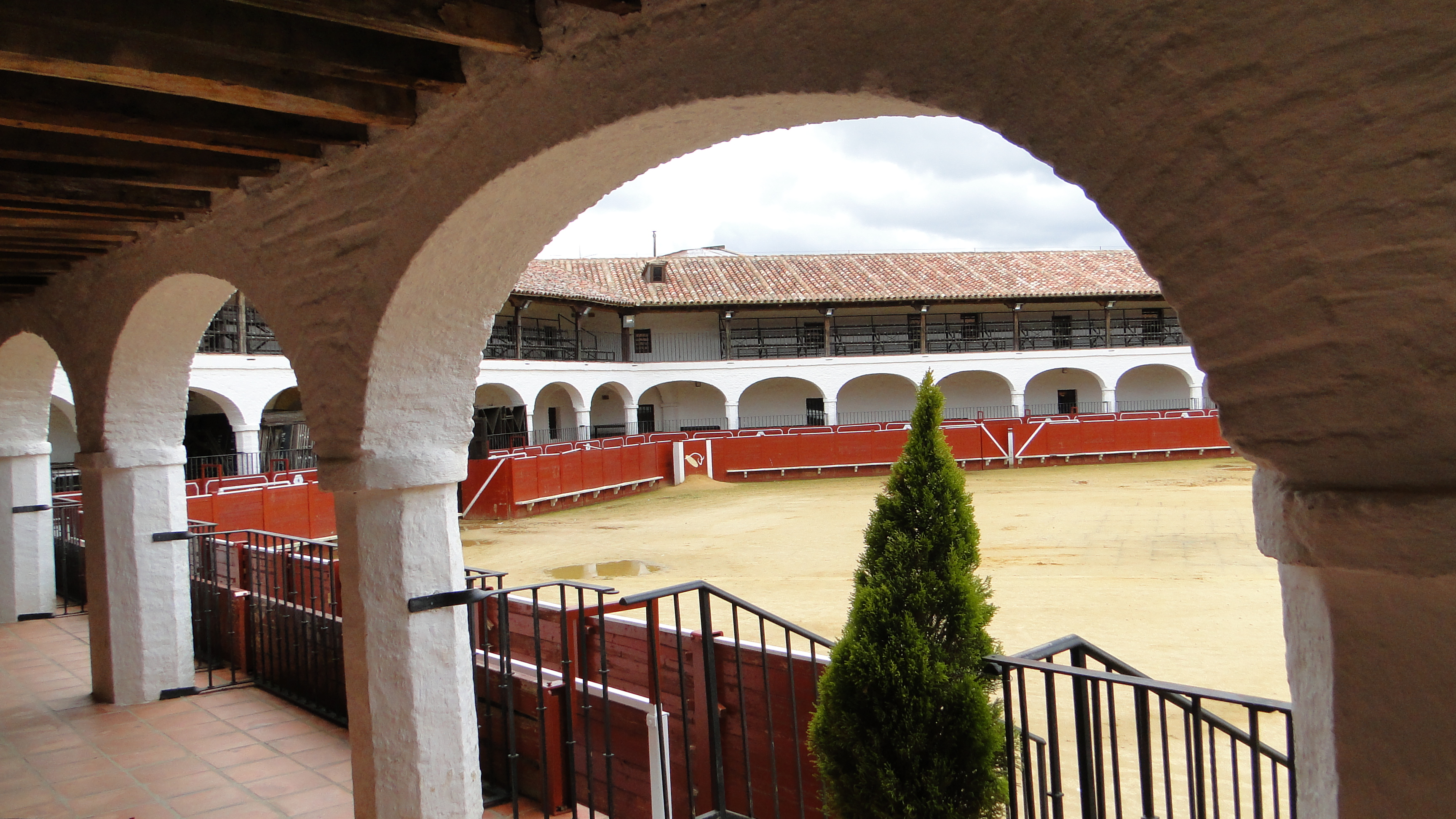 Vista angular exterior de la Plaza de Toros hexagonal de Almadén mostrando sus soportales y viviendas perimetrales